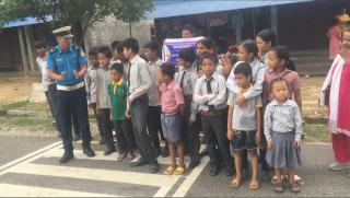 बिद्यार्थीलाई जेब्रा क्रसिङ बाटो काट्न सिकाउँदै देवघाटका ट्राफिक प्रहरी बुद्धि महतो